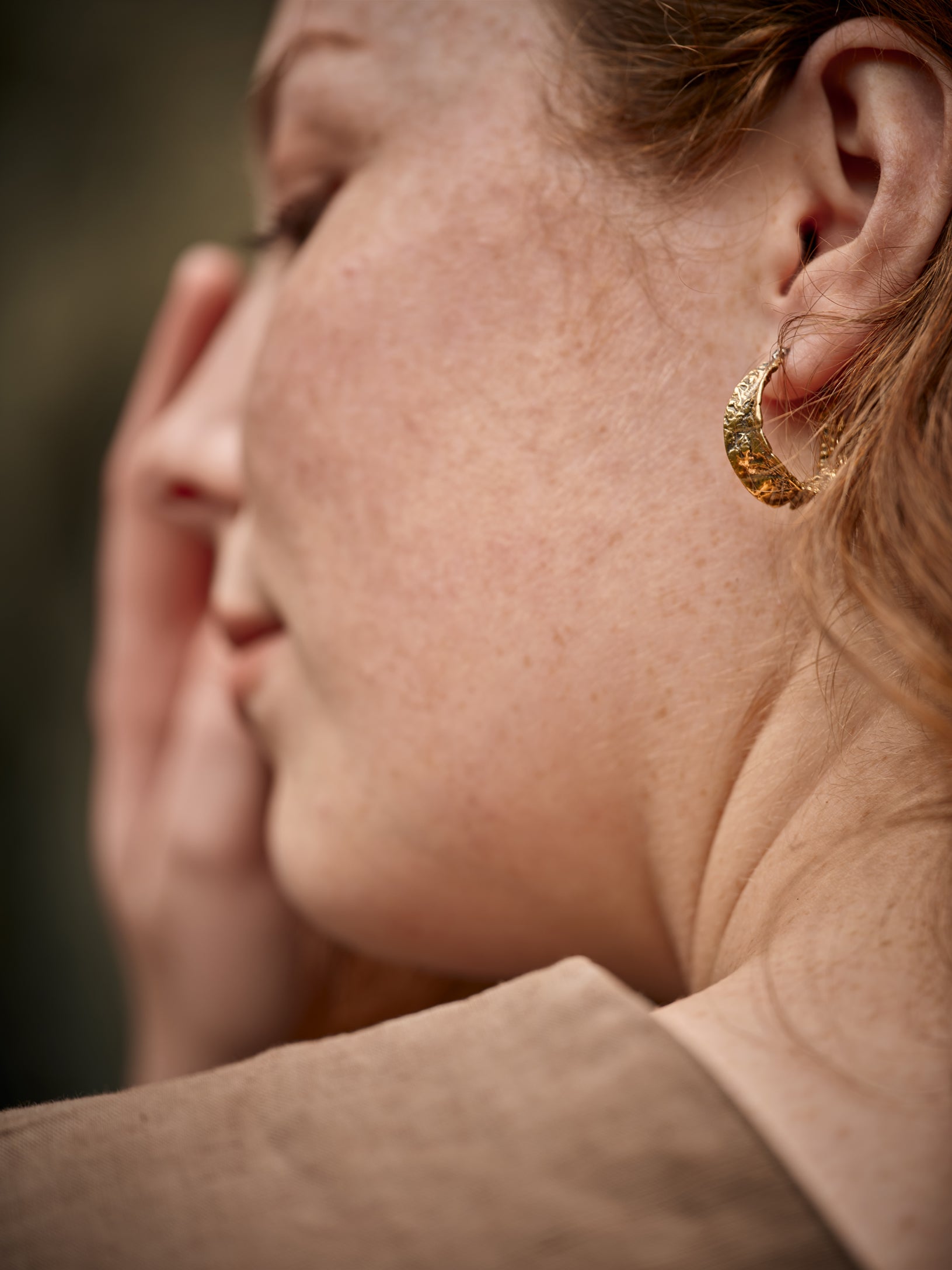 Femme vue de côté portant un anneau d'oreille de couleur or