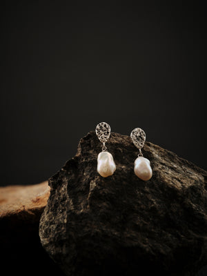 
                  
                    Upload image to gallery, Earrings formed in two parts. The top part is silver and teardrop shaped and is connected to the bottom part which is a white keshi pearl.
                  
                