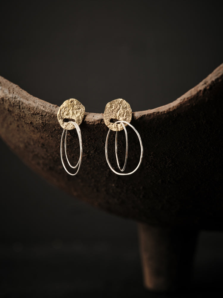 
                  
                    Upload image to gallery, Silver and brass earrings with a textured, openwork brass top into which two small silver hoops are inserted.
                  
                