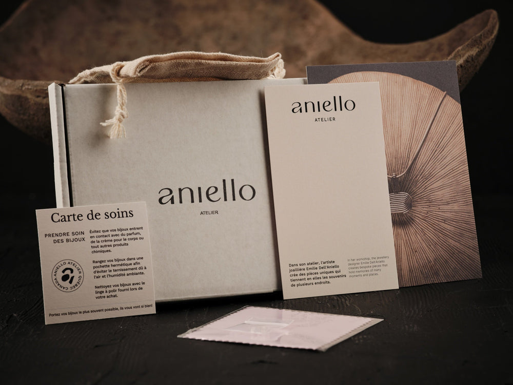 
                  
                    Load image in gallery, Presentation of the complete packaging used by the workshop. A care card, a collection presentation box, a beige linen pouch, a polishing cloth and a cardboard mailing box with the logo.
                  
                