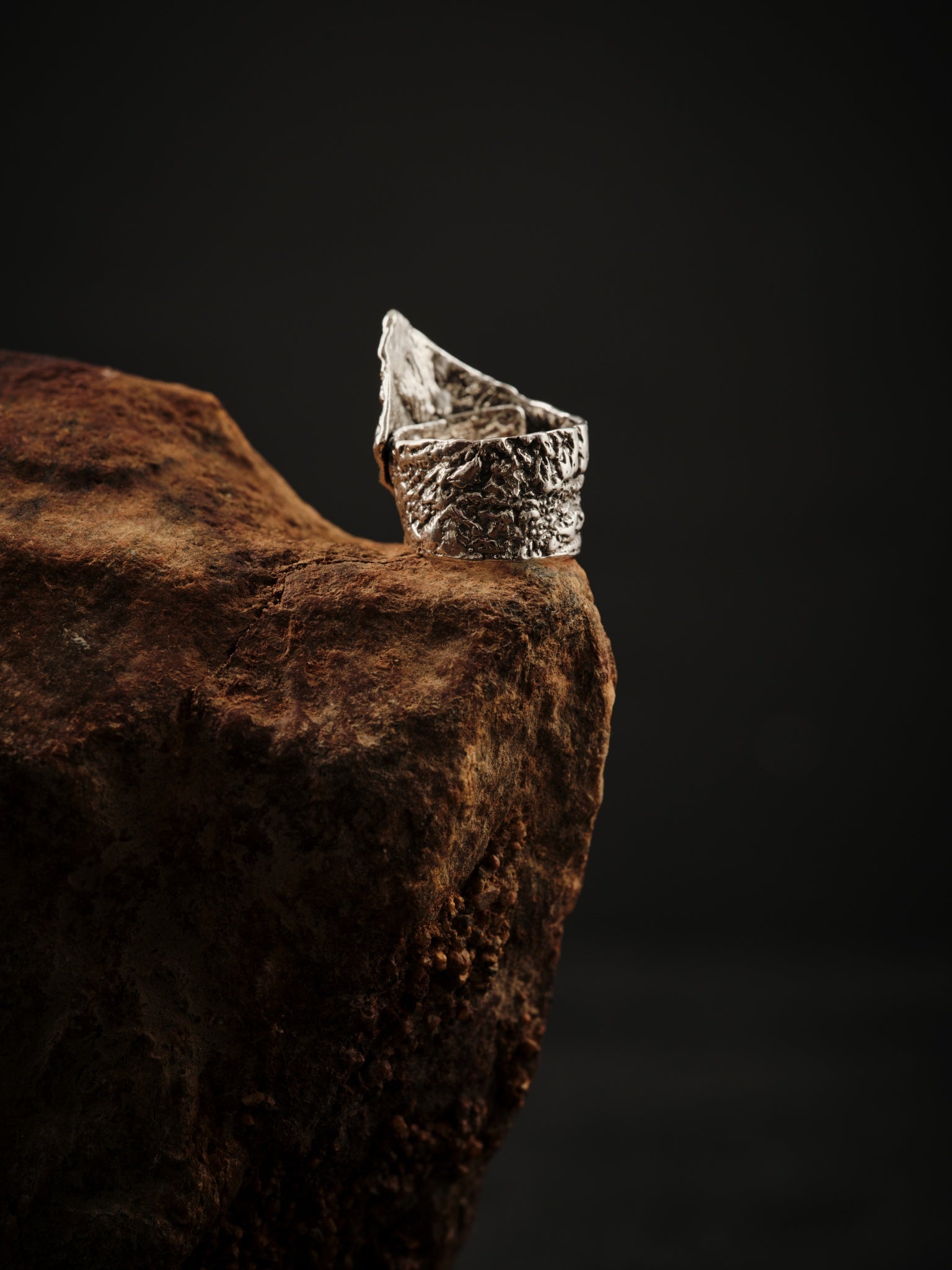 Bague sculpture en argent 925 texturée et ajustable qui repose sur roche. 