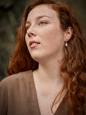 
                  
                    Charger l&amp;#39;image dans la galerie, Portrait 3/4 d&amp;#39;une femme portant des boucles d&amp;#39;oreilles en argent avec une perle blanche
                  
                