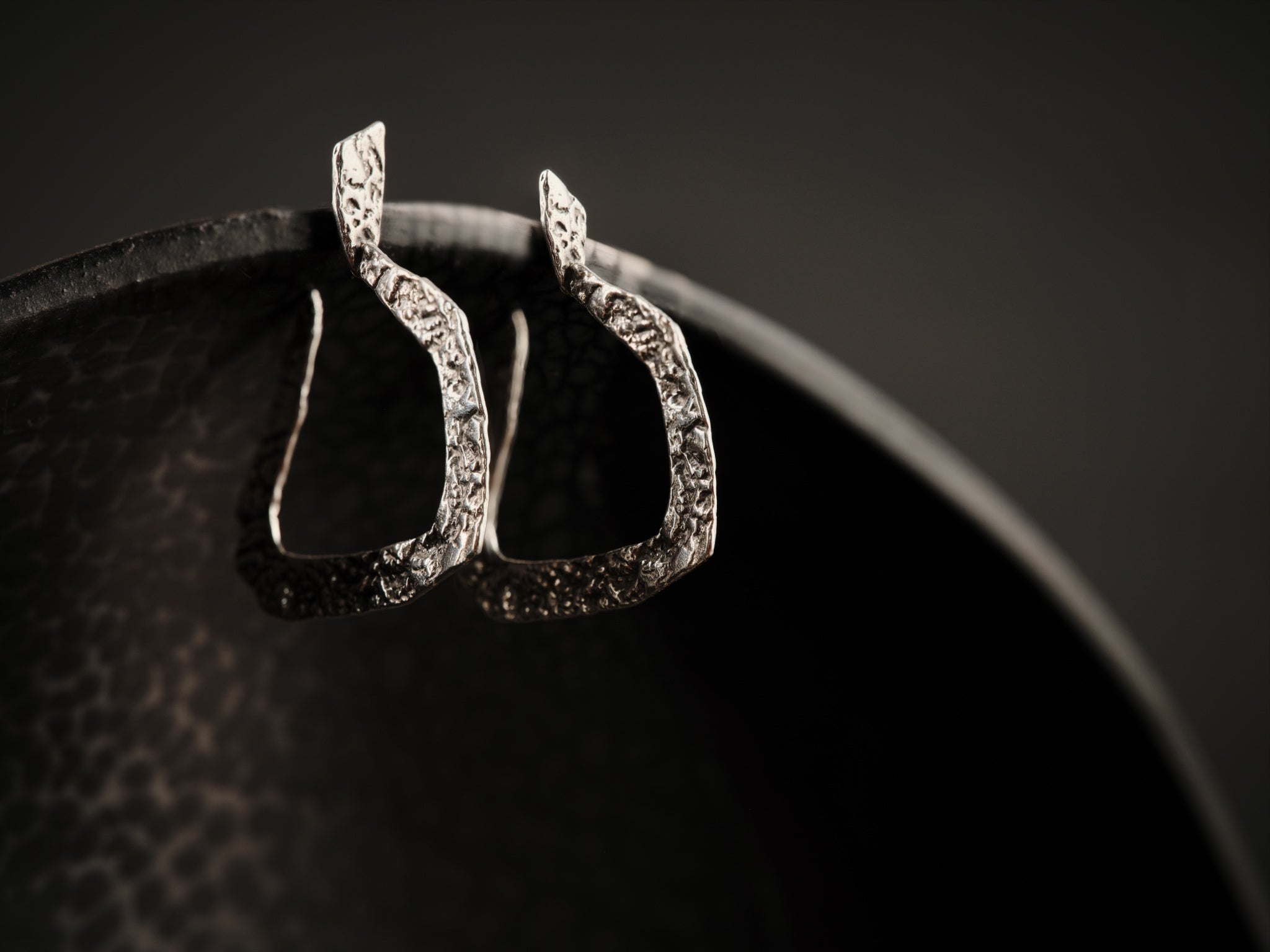Anneaux d'oreilles en argent texturé et de forme géométrique.