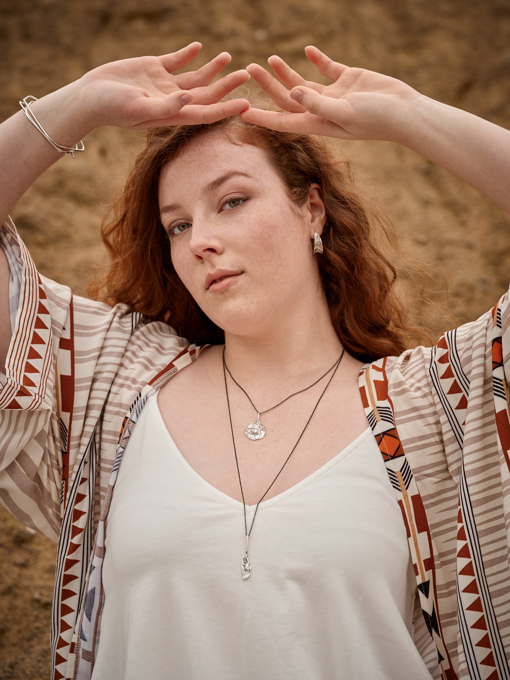 Portrait d'une femme portant deux colliers, trois bracelet et une paire de boucles d'oreilles